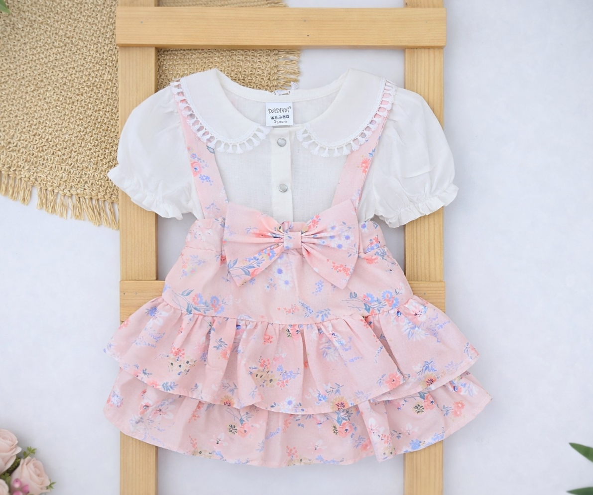 Dvodelni komplet za devojčice – Šarena suknja u kajsija boji na tregere i svečana košuljica sa kratkim rukavima