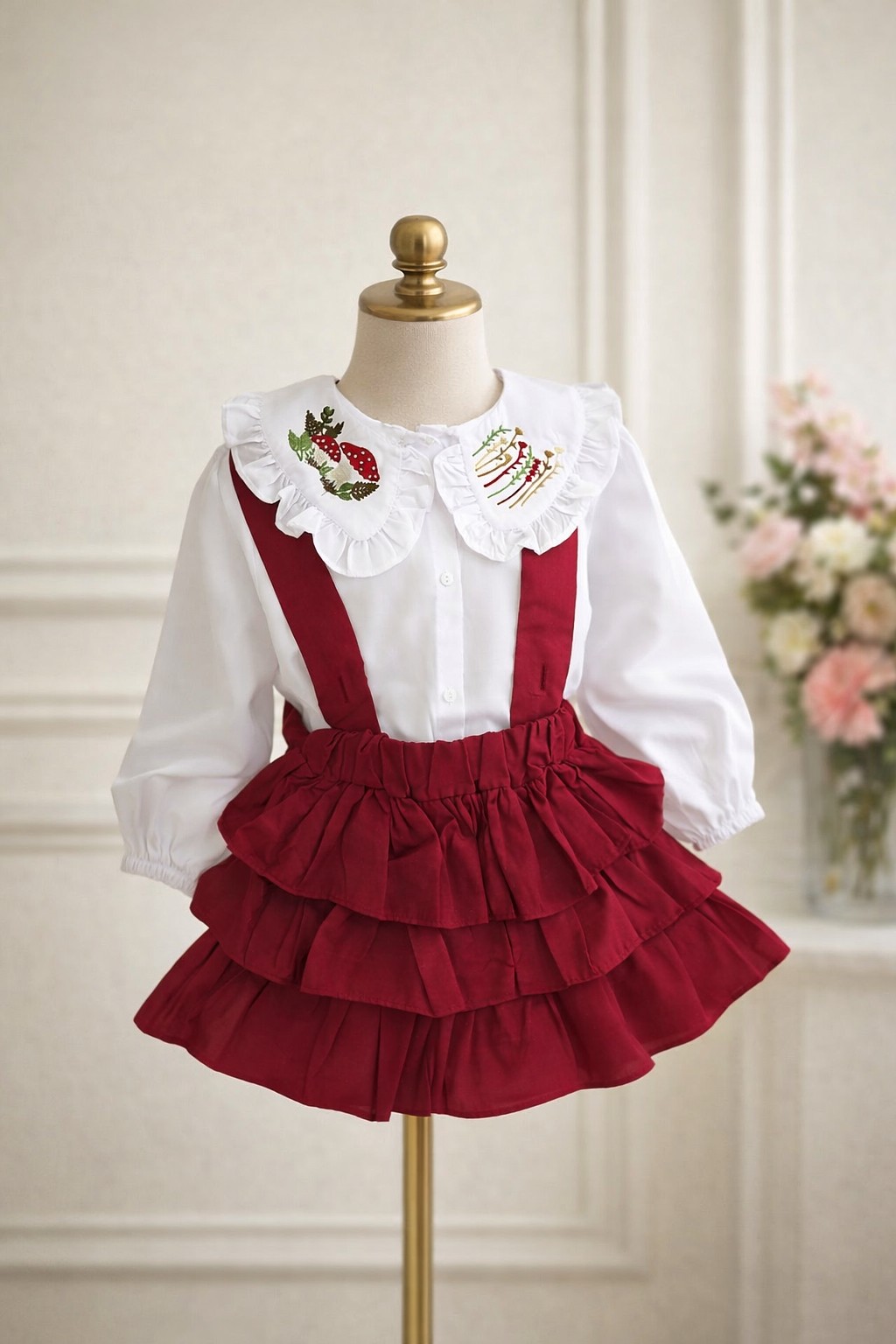 Bela košulja i tamno crvena suknjica sa tregerima i karnerima